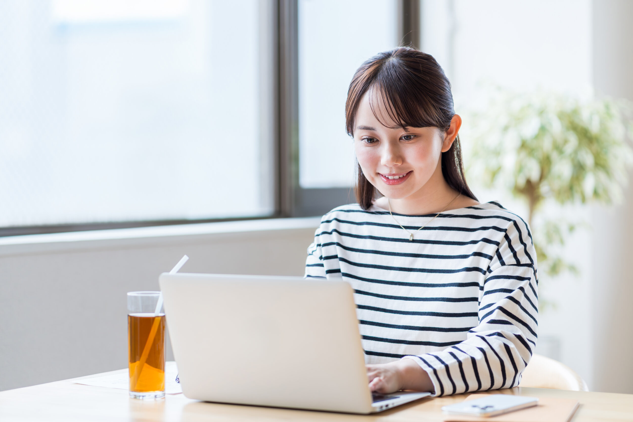 カフェでテレワークをする若い女性