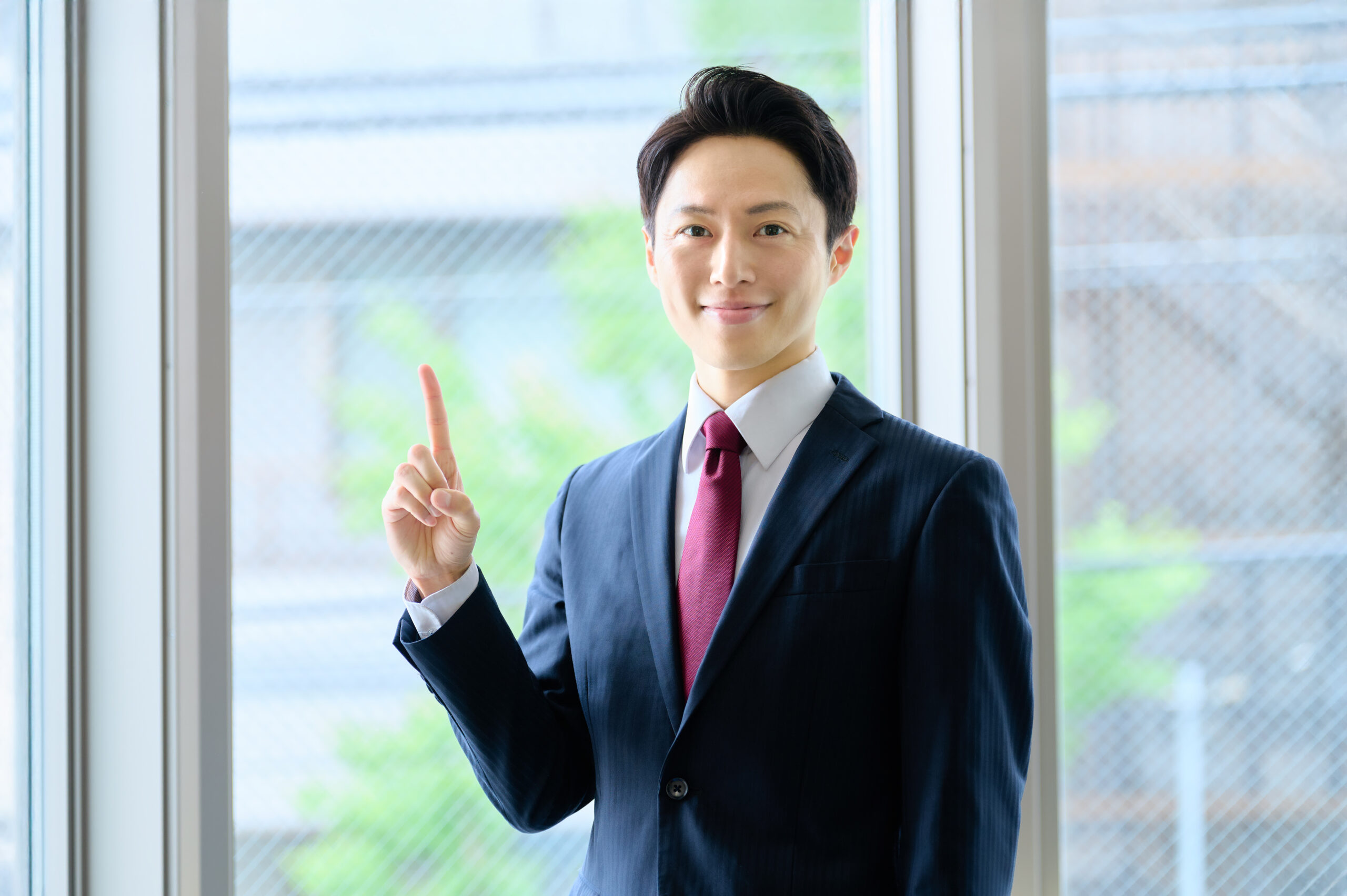 人差し指を立てるビジネスマン